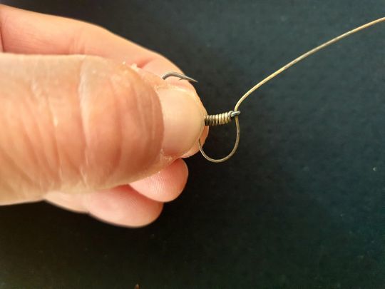 Après la dernière spire, passez à nouveau la tresse dans l'oeillet (par l'extérieur).