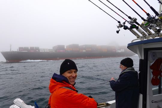 Un cargo porte-conteneur apparait dans le brouillard